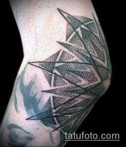 Черно-белое фото минималистичной татуировки на локте, выполненной в технике dotwork. Рисунок состоит из треугольников, соединенных точками, создавая абстрактный узор.