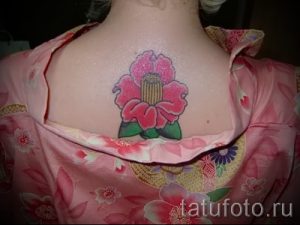 Фото тату пиона на груди. Яркий и красочный рисунок цветка с розовыми лепестками и зелеными листьями. Идеально подходит для женского тела.