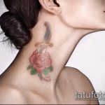 Фото тату на шее девушки: нежная розовая роза, пронзенная кинжалом. Тонкие линии, пастельные тона и элегантный дизайн.