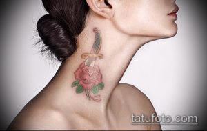 Фото тату на шее девушки: нежная розовая роза, пронзенная кинжалом. Тонкие линии, пастельные тона и элегантный дизайн.