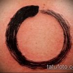 Фото тату: Черный круг Энисо (Zen Circle) на коже. Минималистичный дизайн, японский стиль, тонкая линия, свежая татуировка.