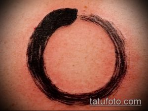 Фото тату: Черный круг Энисо (Zen Circle) на коже. Минималистичный дизайн, японский стиль, тонкая линия, свежая татуировка.