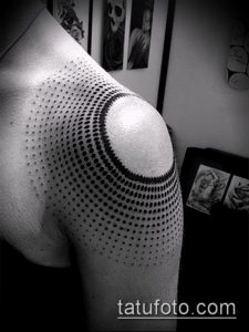Фото татуировки на плече, выполненной техникой pointillism. Черно-белый рисунок состоит из множества точек, создающих эффект градиента.