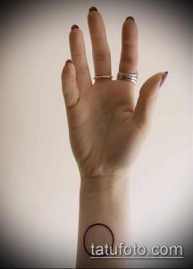 Фото минималистичной тату на запястье с изображением черного круга. Простой и лаконичный рисунок татуировки.