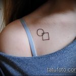 Фото геометрической татуировки на плече с изображением круга и квадрата. Тонкие линии и минималистичный дизайн.