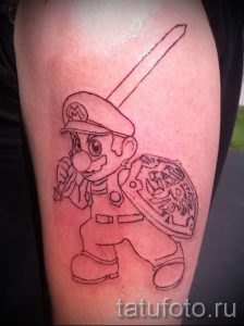 Фото тату на руке: персонаж Марио из игры Super Mario Bros. с мечом и щитом. Простой рисунок татуировки в стиле мультфильма.