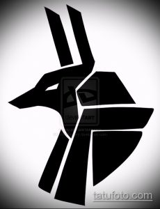 Черно-белая татуировка Анубиса, выполненная в геометрическом стиле. Изображение состоит из острых углов и линий, создающих абстрактный образ бога.