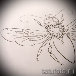 Фото эскиза татуировки пчелы, выполненного в изящном и детализированном стиле. Рисунок с тонкими линиями и узорами, подходит для любителей природы и насекомых.