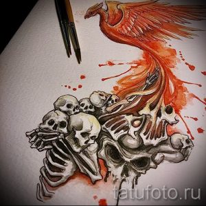 Эскиз татуировки феникса, выполненный в акварельной технике, парящего над кучей черепов. Рисунок сочетает в себе яркие цвета и мрачную символику.