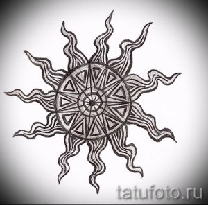 Черно-белое фото эскиза татуировки с изображением солнца, в центре которого расположен сложный геометрический узор. Детализированный рисунок.