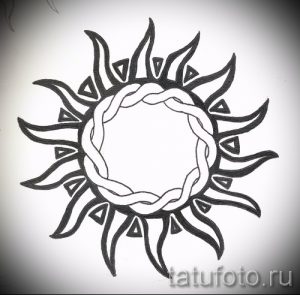 Черно-белое фото эскиза татуировки с изображением солнца в стиле трайбл. Геометрический рисунок с использованием треугольников и линий.