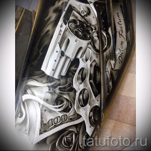 Фото тату: реалистичный рисунок револьвера, окруженного долларами и пламенем. Эскиз для тех, кто ценит смелые и провокационные образы.