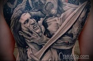 Фото тату на спине: реалистичное изображение падшего ангела, сражающегося с демоном, выполненное в черно-серых тонах.