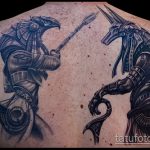 Фото тату на спине с изображением Анубиса и Гора в динамичной позе, словно в разгаре битвы. Детализированный рисунок в реалистичном стиле.