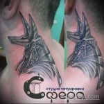 Фото тату: татуировка Анубиса на шее, выполненная в стиле blackwork. Большое количество черного цвета и четкие линии создают эффектный и мрачный образ.