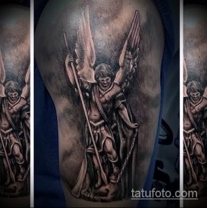 Фото тату архангела Михаила на плече, выполненное в реалистичном стиле с использованием черных и серых оттенков. Изображение включает крылья, доспехи и копье.
