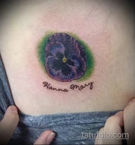Фото тату фиалки с надписью 'Hanna Mary'. Цветы выполнены в ярких фиолетовых тонах с зеленым фоном. Персонализированный дизайн.