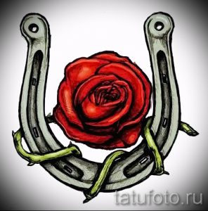 Фото тату с изображением красной розы, заключенной в подкову. Эскиз выполнен в ярких цветах с использованием четких контуров и детализированной прорисовки.