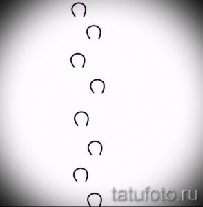 Фото эскиза татуировки, состоящего из нескольких подков, расположенных вертикально. Черно-белый минималистичный рисунок.