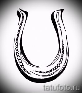 Черно-белая татуировка подковы с тонкими линиями и точками. Простой и элегантный дизайн для любителей минимализма.
