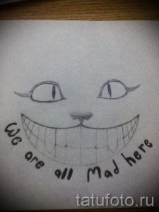 Простой эскиз тату Чеширского кота с его знаменитой улыбкой и надписью "We are all Mad here". Черно-белый рисунок.