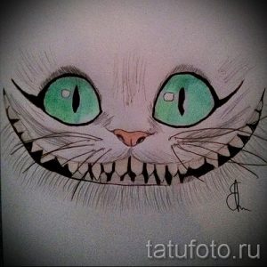 Эскиз тату Чеширского кота с акцентом на его жуткую улыбку и острые зубы. Зеленые глаза придают изображению зловещий вид.