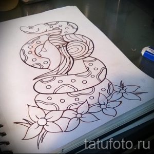 Эскиз татуировки с изображением змеи, обвивающей цветы. Черно-белый рисунок с четкими контурами и детальной проработкой узора на теле змеи.