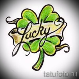 Фото татуировки с изображением четырехлистного клевера и надписью "Lucky", выполненной в каллиграфическом стиле. Символ удачи и позитива, идеально подходит для тех, кто верит в чудеса.
