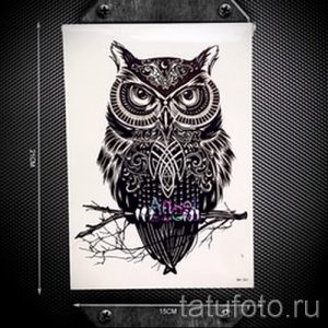 Фото черно-белого эскиза татуировки совы в стиле орнамент, сидящей на ветке дерева.