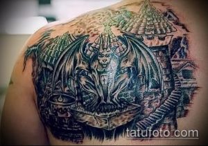 Фото тату горгульи на спине, выполненное в реалистичном стиле с использованием черных и серых оттенков. Детализированный рисунок с элементами готической архитектуры.