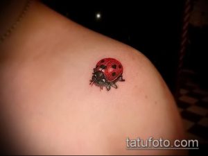Фото тату маленькой божьей коровки на плече. Небольшой, аккуратный рисунок татуировки в минималистичном стиле.