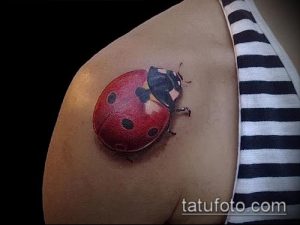 Фото тату реалистичной божьей коровки на плече. Детальный рисунок татуировки с проработкой текстуры крыльев и тела насекомого.