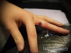 Фото тату маленькой божьей коровки на пальце. Небольшой, аккуратный рисунок татуировки в минималистичном стиле.