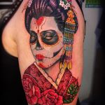 Фото тату в стиле Day of the Dead с изображением гейши в виде калаверы, украшенной цветами и традиционными элементами.