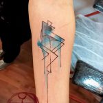 Фото тату на предплечье: абстрактная композиция из геометрических фигур и акварельных пятен в сине-черной гамме.