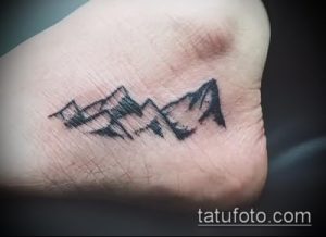 Фото тату на пятке с изображением гор. Простой, черно-белый рисунок татуировки в минималистичном стиле. Идеальный эскиз тату для любителей природы.