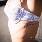 Фото тату: изящная татуировка с изображением горной цепи на боку, выполненная в тонких линиях. Женственный и минималистичный эскиз тату.