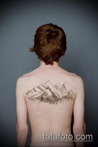 Фото тату гор на мужской спине. Черно-белый рисунок, минималистичный стиль, тонкие линии.