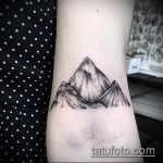 Фото тату гор на запястье. Черно-белый рисунок, точечная техника, графичный стиль.