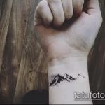 Фото тату: минималистичная татуировка горного силуэта, выполненная тонкими линиями на запястье.
