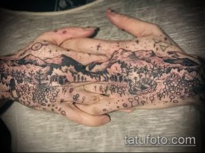 Фото тату: детализированная татуировка пейзажа с горами, лесом, животными и растениями, покрывающая обе ладони.