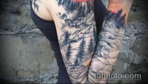 Фото пейзажной татуировки с изображением гор, леса и оленя на руке. Черно-белая гамма и детализированная проработка.