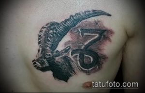 Фото тату козла с числом 666 на груди, выполненное в черно-серых тонах с добавлением красных акцентов. Реалистичный рисунок татуировки.