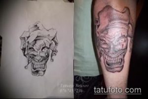 Фото эскиза татуировки в виде маски клоуна, выполненной в черно-серых тонах. Рисунок изображает зловещую маску с острыми зубами и выразительными глазами.