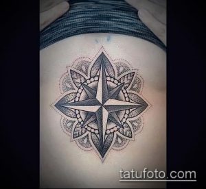 Фото тату в технике dotwork с изображением розы ветров на спине. Татуировка выполнена черными точками и имеет сложный узор.