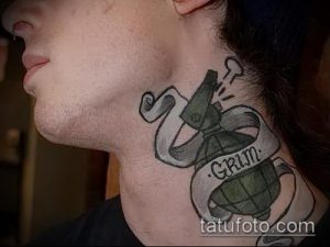 Фото тату гранаты с надписью "GRIM" на шее. Рисунок татуировки в черно-серых тонах.