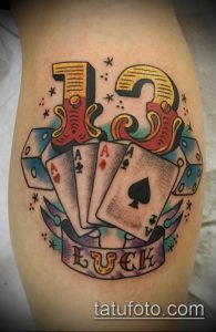 Фото тату на ноге: число 13, карты, кости и надпись 'LUCK', стиль old school, яркие цвета.