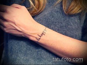 Фото тату: надпись 'be happy' на запястье, выполненная тонким шрифтом. Минималистичный и позитивный рисунок татуировки.