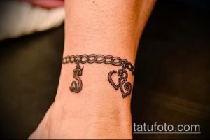 Фото тату: тонкий браслет на запястье с буквами 'S' и 'R', выполненный в стиле минимализм. Изящный рисунок татуировки.