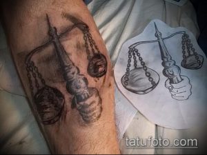Фотография татуировки весов на предплечье, рядом с эскизом. Изображение выполнено в реалистичном стиле с использованием теней и полутонов.
